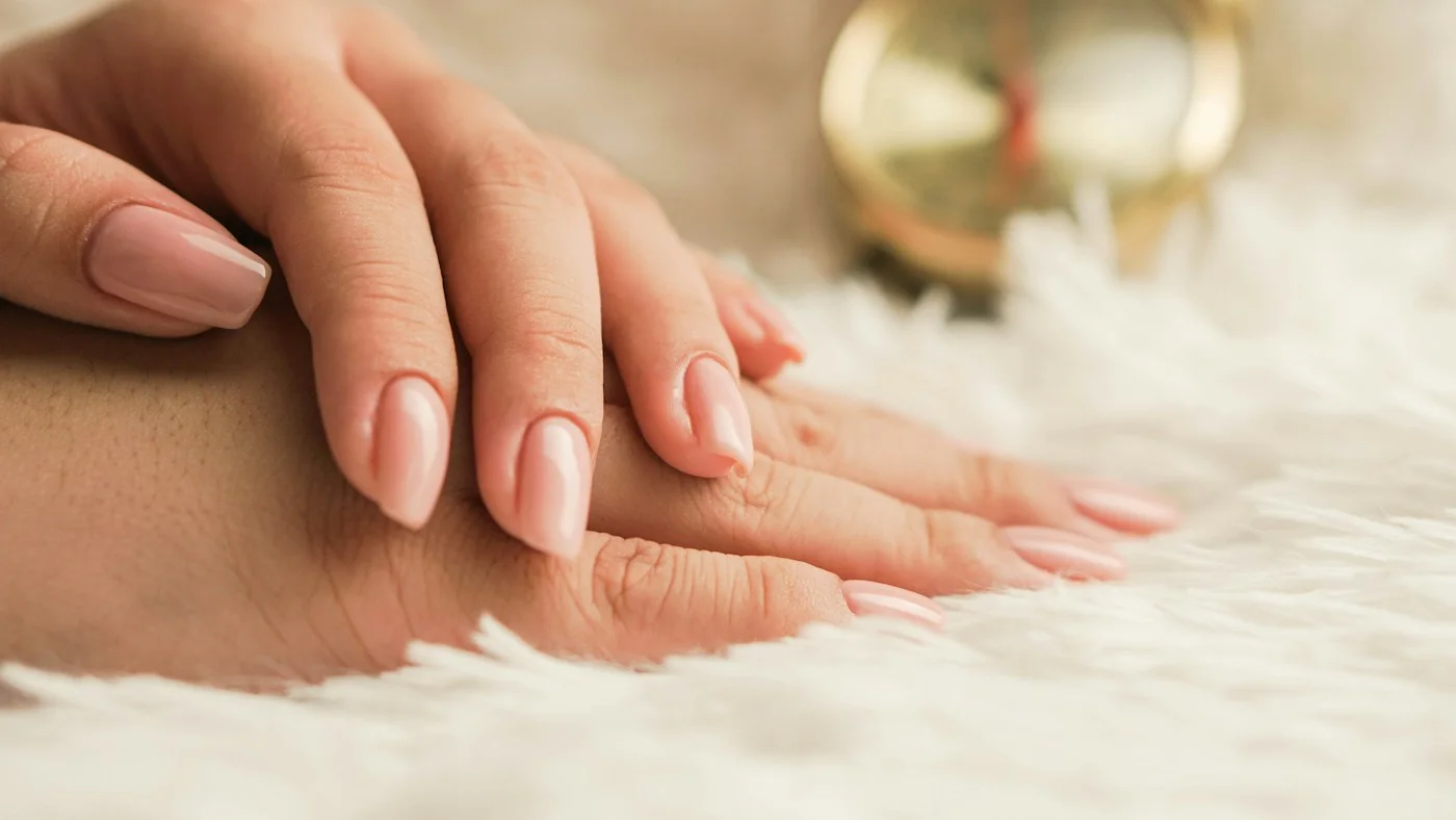 Elegant hands with a soft nude manicure